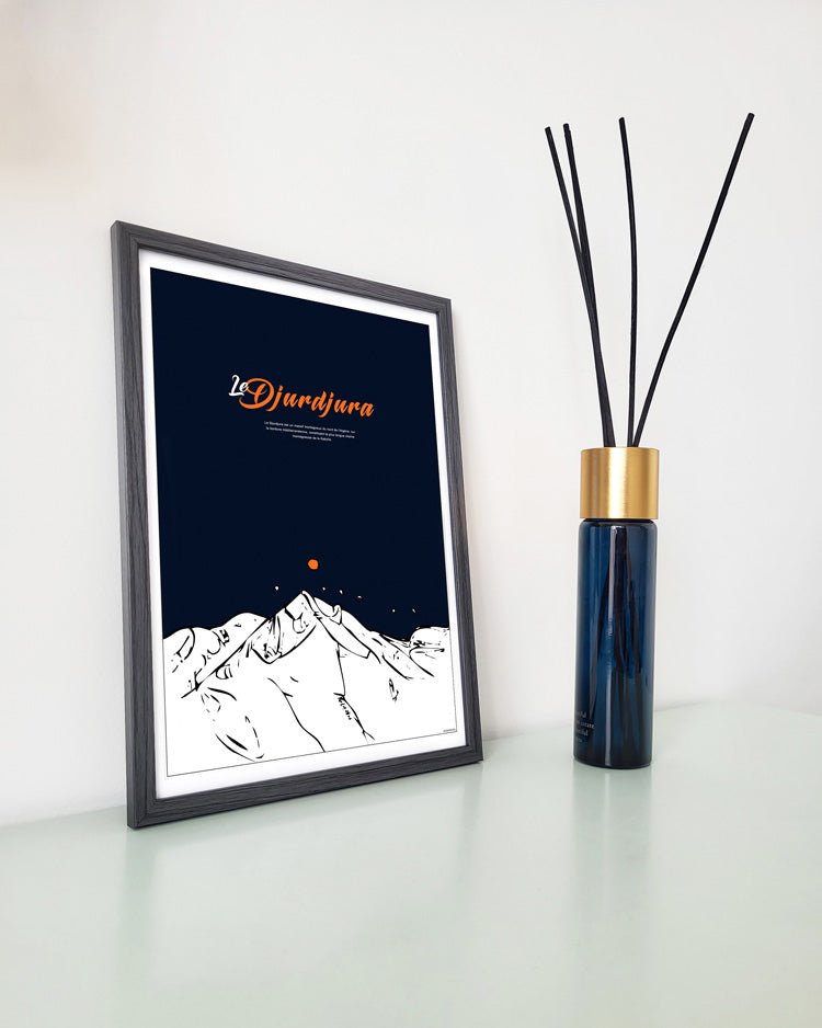 Une affiche murale dans son cadre de Djurdjura en latin posée sur un bureau à coté d'encens diffuseur de parfum par azamoul mode et accessoires berbères amazighs et de décoration intérieure