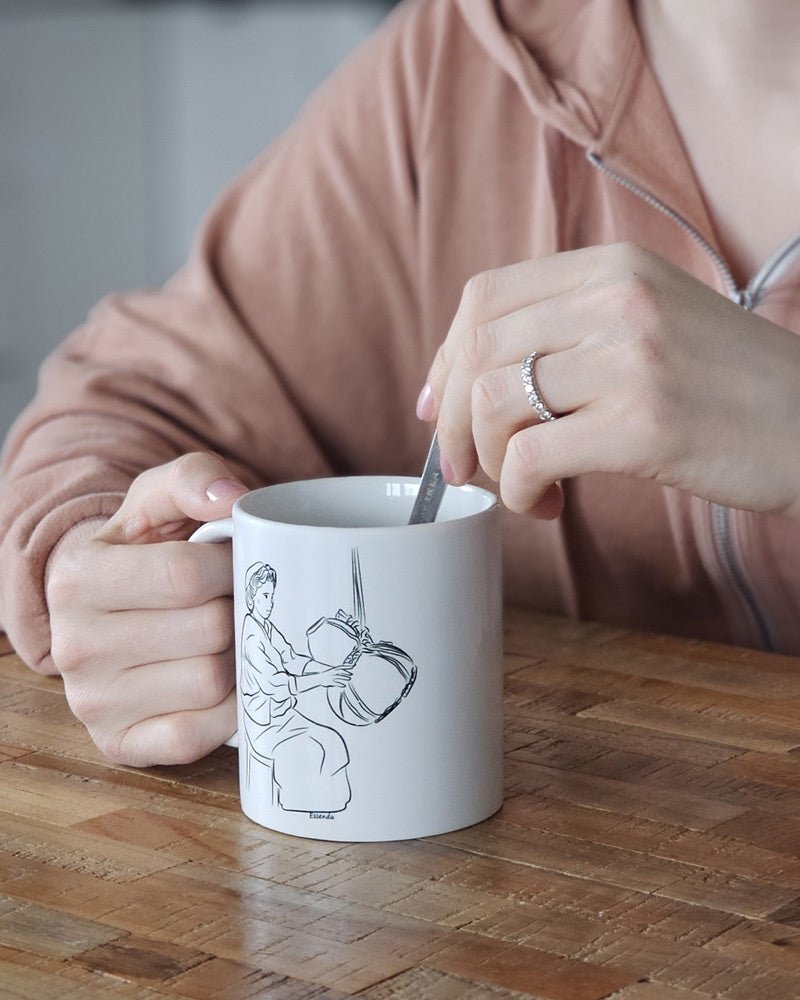 Un mug en céramique essendu, une tradition kabyle amazigh berbère entre les mains d'une femme qui boit son café, une tasse pour café ou thé fabriqué en france, azamoul mode et accessoires berbères amazigh et décoration intérieure