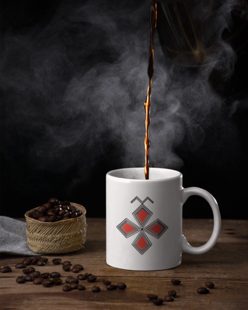Mug en céramique avec symbole berbère amazigh de la dualité, à côté d'un petit panier de graines de café, fabriqué en France, par Azamoul. Idéal pour café ou thé, Accessoire berbère amazigh pour décoration intérieure