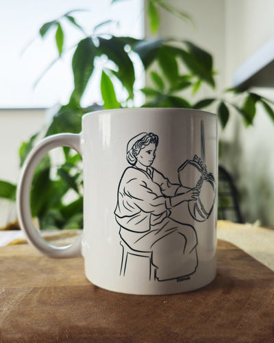 Un mug essendu en céramique posé sur une table dans un salon, atmosphère chaleureuse avec une plante en arrière plan, tasse pour café ou thé fabriqué en france, azamoul mode et accessoires berberes amazigh et décoration intérieure