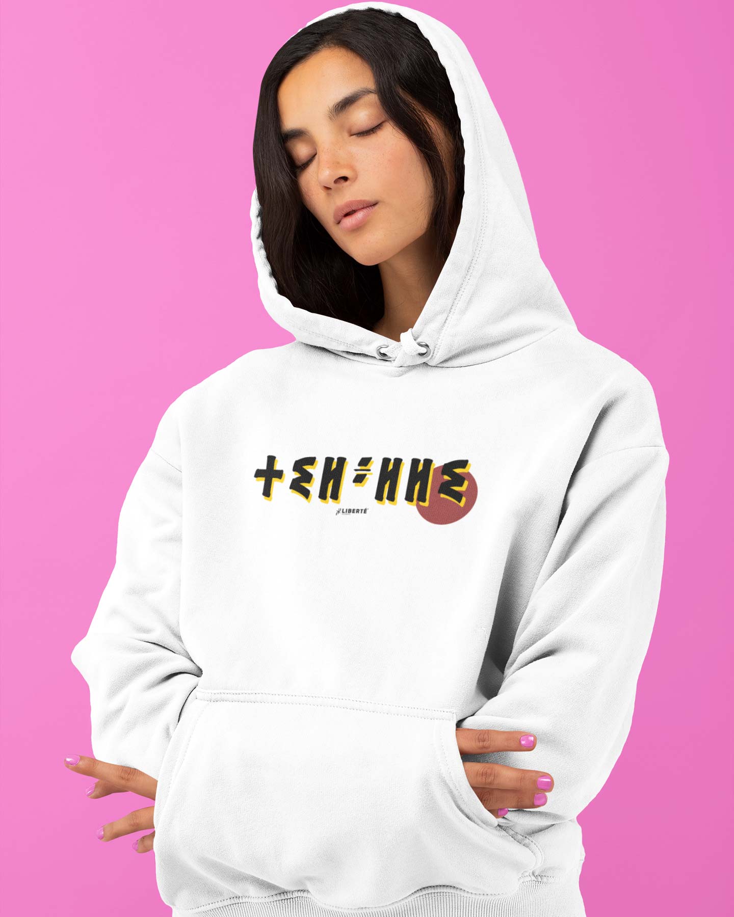 Femme qui porte un sweat à capuche thilelli liberte 100% coton bio, écrit en langue tifinagh, la langue des berbères amazigh par Azamoul mode et accessoires berbères,  de couleur blanc