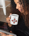Un mug en céramique avec le symbole berbère de la dualité, tenu entre les mains d'une femme qui lit un livre, fabriqué en France, azamoul mode et accessoires berbères amazigh et décoration intérieure