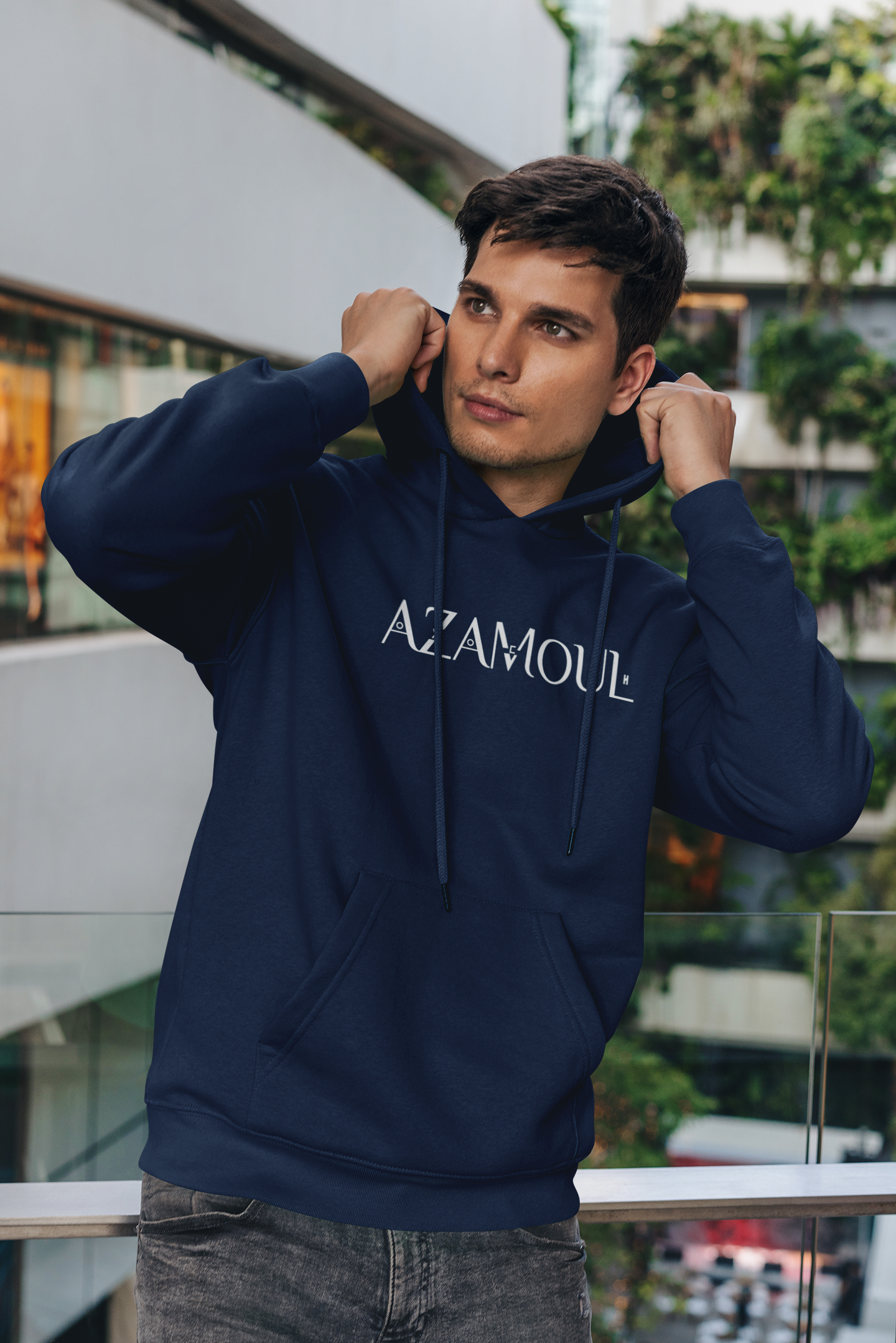 Sweat à capuche Azamoul écrit en tifinagh porté par un homme dans un immeuble regardant de loin, par azamoul mode et accessoires berbères amazigh couleur bleu marine