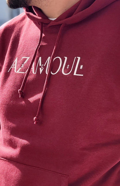 Sweat à capuche Azamoul écriture supplémentaire en tifinagh langue berbère amazigh pour Homme  porté par un homme en plein soleil par azamoul mode et accessoires berbères couleur bordeaux
