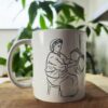 mug-essendou-made-in-franceazamoul-436224_91f95541-d080-4687-a187-2b9b3fb624c9 Un mug essendu la tradition kabyle berbère amazigh en céramique posé sur une table dans un salon, atmosphère chaleureuse avec une plante en arrière plan, tasse pour café ou thé fabriqué en france, azamoul mode et accessoires berberes amazigh et décoration intérieure