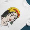 T-shirt blanc femme berbère kabyle Amazigh par Azamoul Mode et Accessoires Berbères : design traditionnel avec tatouage facial symbolique, foulard kabyle amendil coloré, bijoux berbères et symbole berbère. Portez votre identité fièrement
