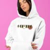 Femme qui porte un sweat à capuche thilelli liberte 100% coton bio, écrit en langue tifinagh, la langue des berbères amazigh par Azamoul mode et accessoires berbères,  de couleur blanc