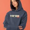 Femme qui porte un sweat à capuche thilelli liberte 100% coton bio, écrit en langue tifinagh, la langue des berbères amazigh par Azamoul mode et accessoires berbères,  de couleur marine