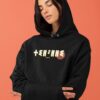 Femme qui porte un sweat à capuche thilelli liberte 100% coton bio, écrit en langue tifinagh, la langue des berbères amazigh par Azamoul mode et accessoires berbères,  de couleur noir