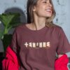 T-shirt Azamoul Thilelli écrit en lettre Tifinagh alphabet berbère amazigh porté par une femme souriante - couleur bordeaux  - 100% coton bio made in france