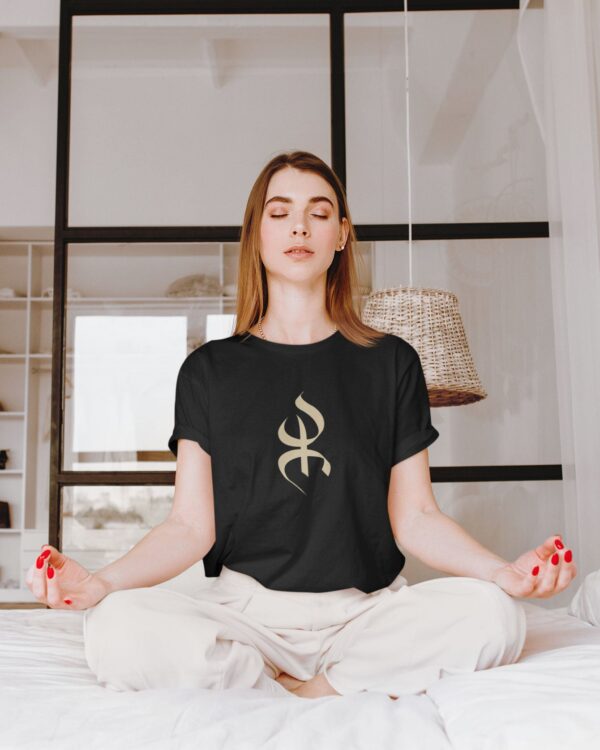YAZ_tshirt-femme-amazigh-azamoul-mode-accessoires-berberes-noir Femme berbère kabyle dans sa chambre en position de méditation portant un tshirt amazigh yaz noir par azamoul mode et accessoires berbères