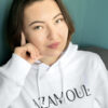 sweat a capuche portée par une femme aux cheveux longs, avec le logo azamoul écrit en tifinagh qui signifie symbole en langue berbère amazigh tifiangh, portez votre identite, par azamoul mode et accessoires berbères
