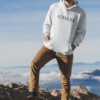 Sweat à capuche pour homme, couleur blanc porté par un homme dans les montagnes regardant de loin avec un bonnet, par azamoul mode et accessoires berbères amazigh