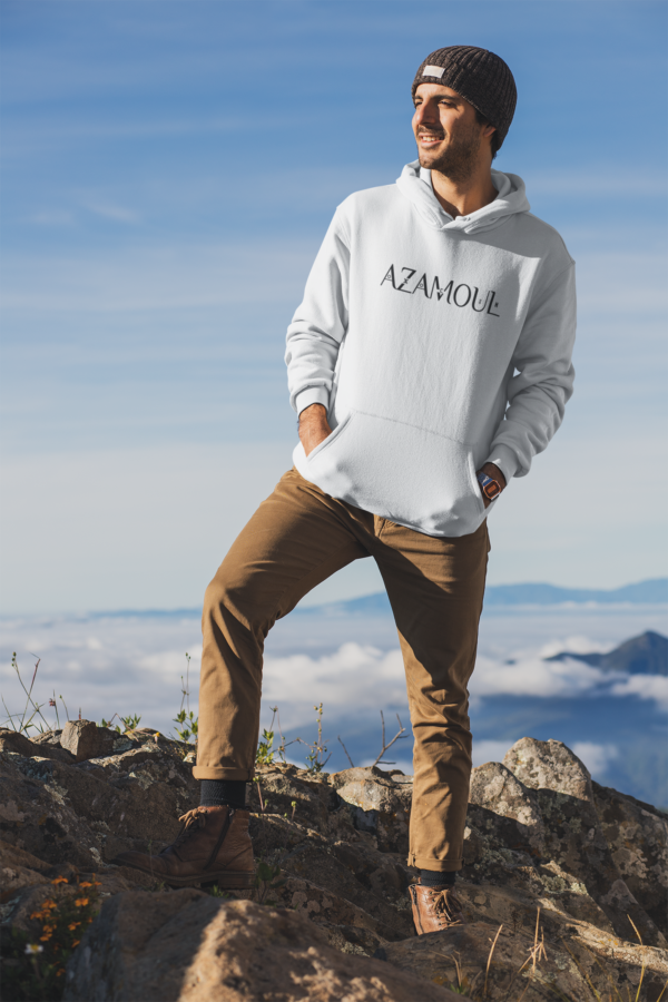 Sweat à capuche pour homme, couleur blanc porté par un homme dans les montagnes regardant de loin avec un bonnet, par azamoul mode et accessoires berbères amazigh