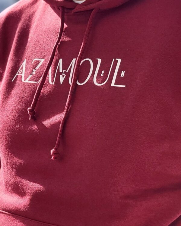 Sweat à capuche Azamoul écriture supplémentaire en tifinagh langue berbère amazigh pour Homme  porté par un homme en plein soleil par azamoul mode et accessoires berbères couleur bordeaux