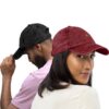 Homme et Femme portent casquettes vintage noire et rouge brodée au symbole YAZ de liberté et noblesse chez les amazighs par azamoul mode et accessoires berbères
