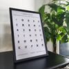 Affiche murale de l'alphabet berbère, Tifinagh, de couleur noire posée sur un bureau à coté d'une fleur dans un cadre de décoration intérieure par Azamoul mode et accessoires berbères amazigh