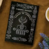 Le livre Paroles De Symboles par Noureddine Hamouche posé sur une table à coté de fleur et tasse de café - sur Azamoul mode et accessoires berbères amazigh.