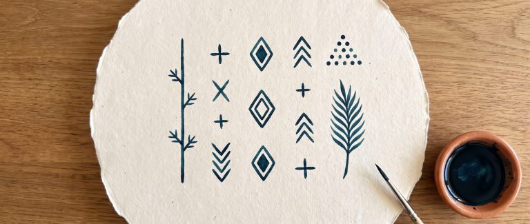 Motifs du tatouage berbère traditionnel dessinés à l encre indigo : ligne du menton, croix, losanges et chevrons